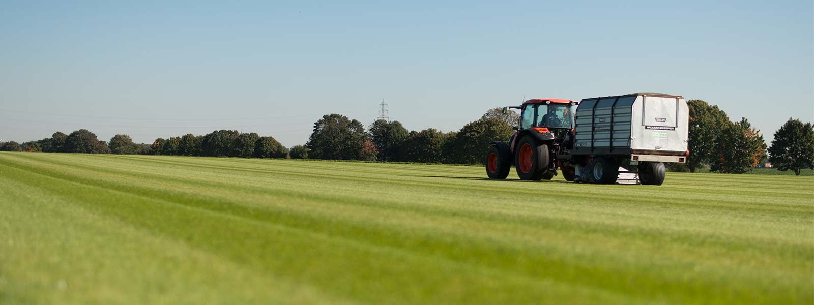 Rollrasen-Feld in Pulheim mit Traktor und Vakuumsweeper bei der Pflege
