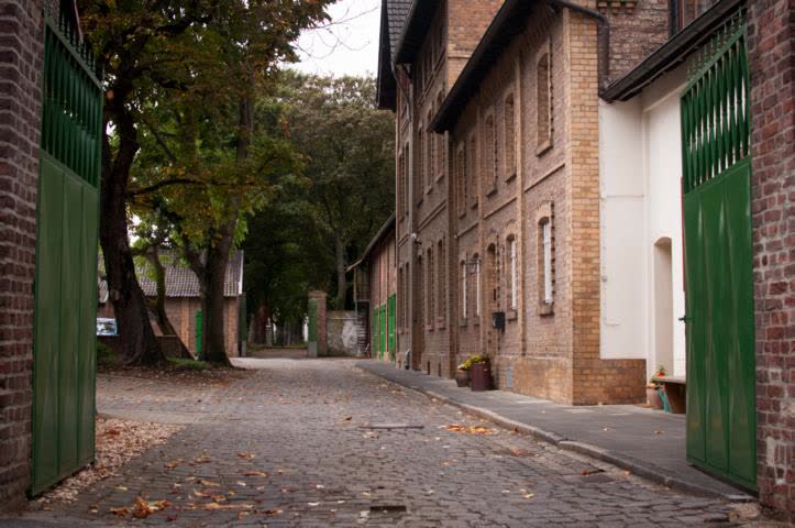 Hofeinfahrt zum Großen Kreuzhof — Klinkergebäude mit grünen Toren